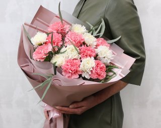 Букет из 15 розовых и белых гвоздик в стильной упаковке с зеленью